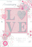 In this image, the anniversary card is a gentle ode to enduring romance, blending soft pastel pinks and muted silvery greys into a design that feels both intimate and timeless, like a quiet evening at home in Ruislip. At the centre, the word LOVE is formed from raised, softly sparkling glitter, each letter rounded and tactile. The O is replaced by a shimmering silver heart, textured so it appears to glow slightly against the surrounding blush background. Around this central emblem, clusters of delicate blooms open in shades of blush, mauve, and creamy ivory, painted with an almost watercolour softness. Their fine outlines and subtle shaded petals suggest the careful hand of an artist-and echo the attention to detail a florist brings when creating romantic arrangements for local deliveries across Ruislip. Slender vines curl between the flowers, and tiny flourishes-floating petals, airy swirls, and discreet butterflies-give a sense of gentle motion, like a soft breeze moving through a spring garden. The inscriptions On Our Anniversary and I love you today and always are printed in graceful, understated scripts that drift across the design like trailing ribbon. The composition is balanced and soothing, free from harsh lines or bold colours, inviting the eye to rest on its tender details. It feels very much like a keepsake card chosen from a favourite Ruislip shop, ready to be propped beside a vase of fresh blooms on an anniversary table, quietly whispering gratitude, devotion, and the promise of many more shared days to come.